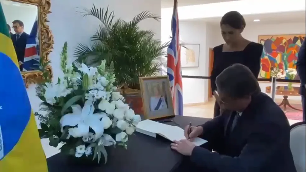 O presidente Jair Bolsonaro, acompanhado da primeira-dama, Michelle Bolsonaro, assinou o livro de condolências da rainha Elizabeth II — Foto: Secom/ Palácio do Planalto